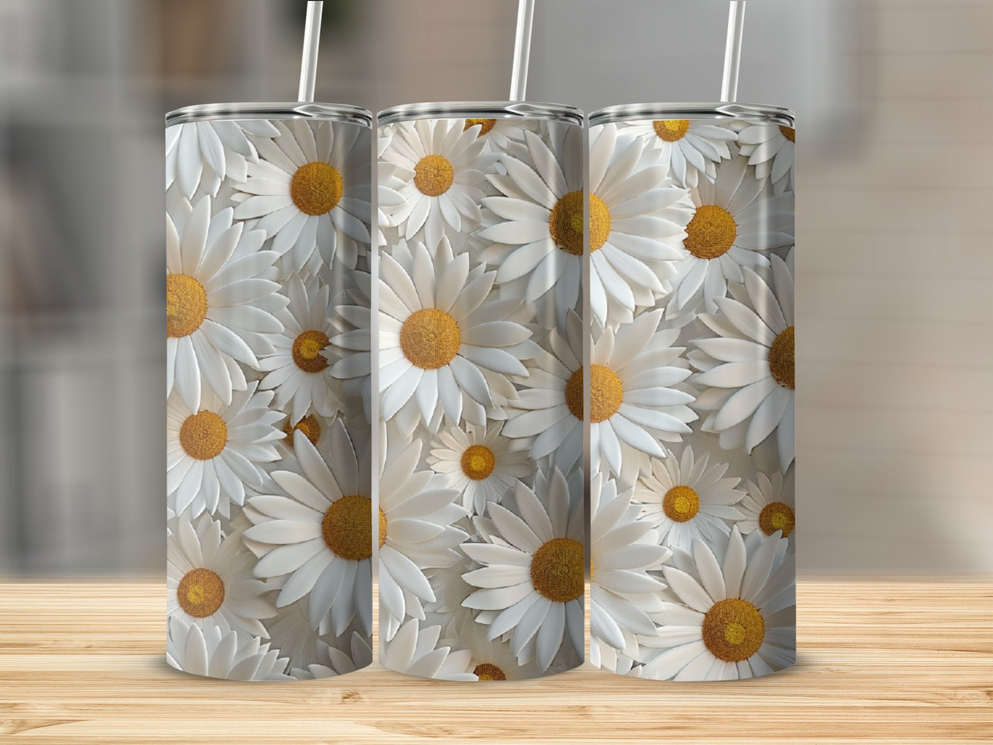 Three tumblers with a white daisy floral pattern on a wooden surface.