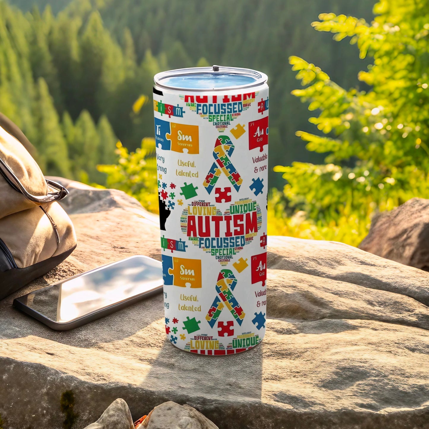 Autism awareness tumbler with colorful puzzle pieces and words like "Focused" and "Loving."
