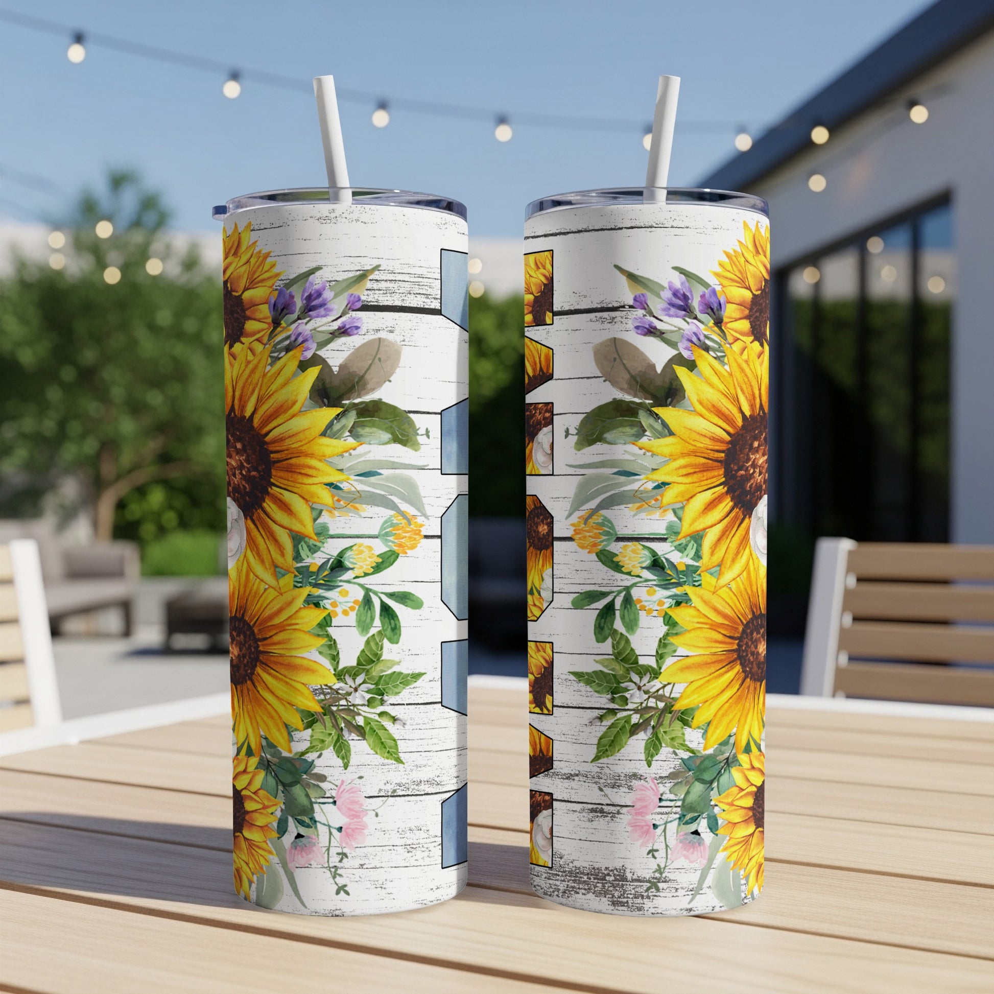 Two tall tumblers with sunflowers and floral accents on a wooden table.