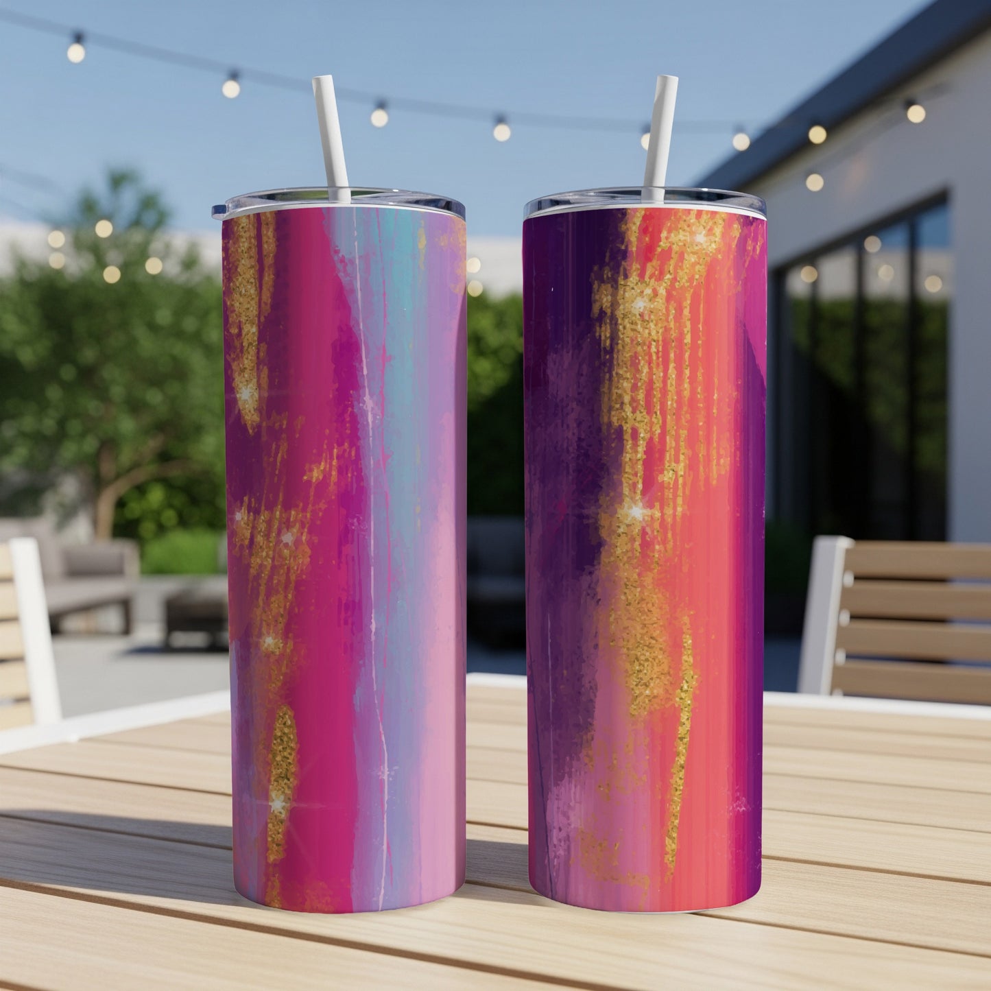Two tumblers with abstract pink, purple, and gold glitter designs and white straws.