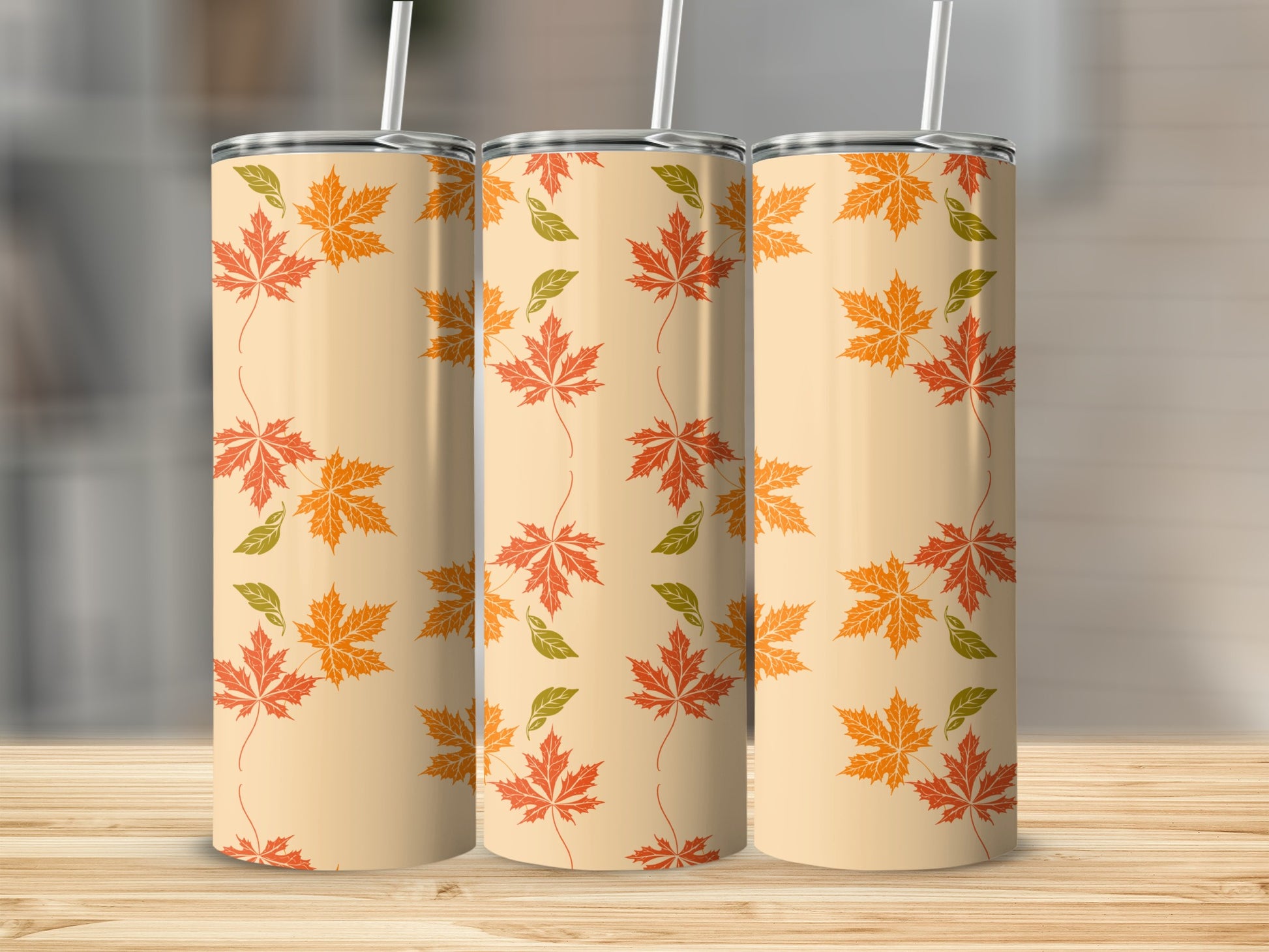 Three tumblers with an autumn leaf pattern on a wooden surface.