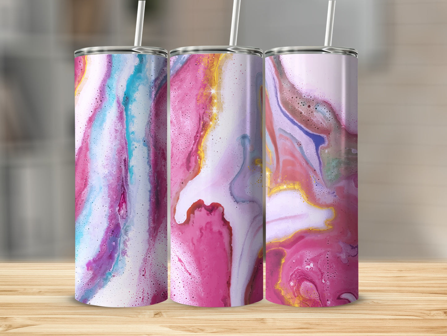 Three tumblers with marbled pink, blue, and purple abstract designs on a wooden surface.