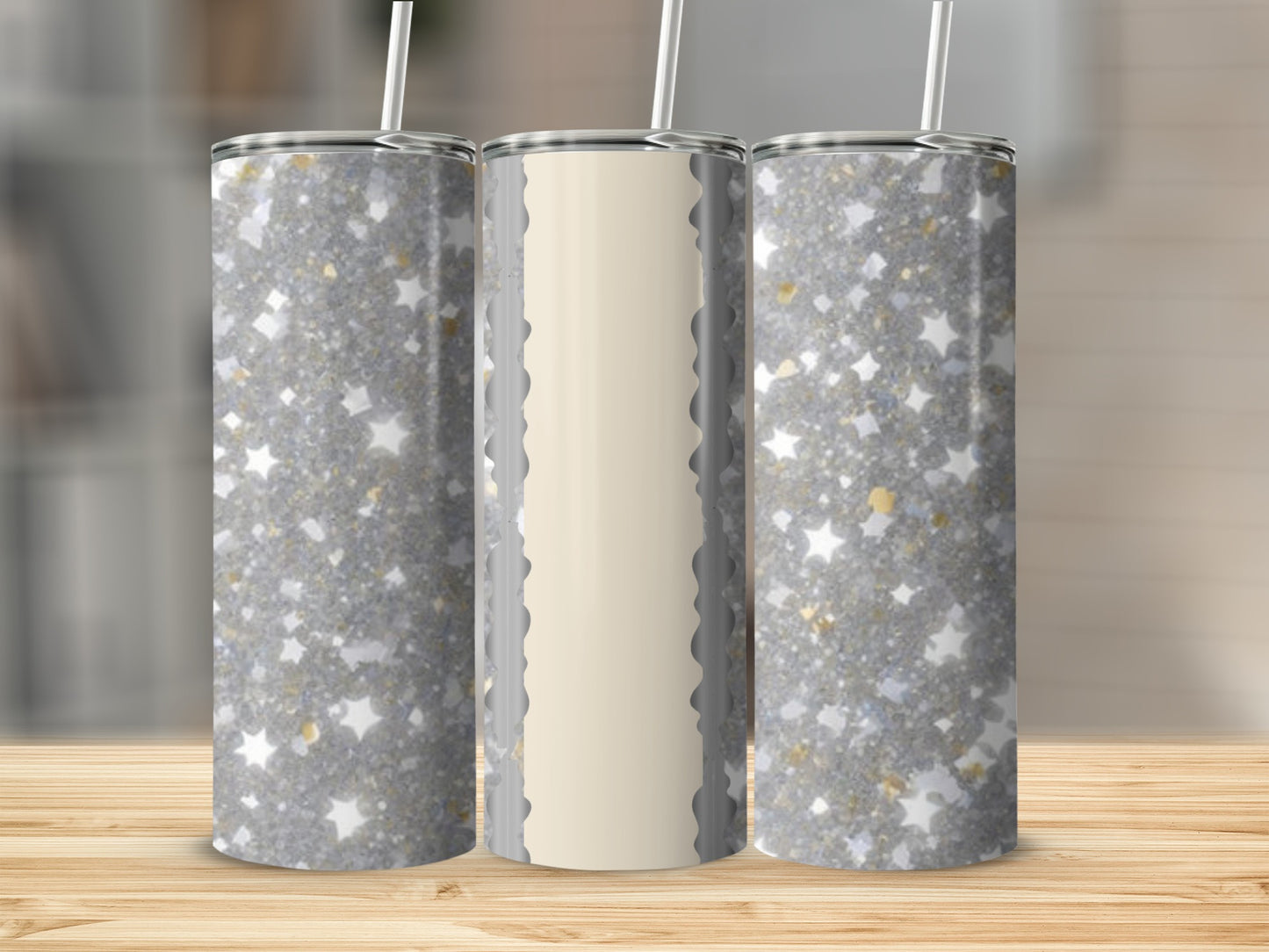 Three silver glitter tumblers with straw on a wooden surface.