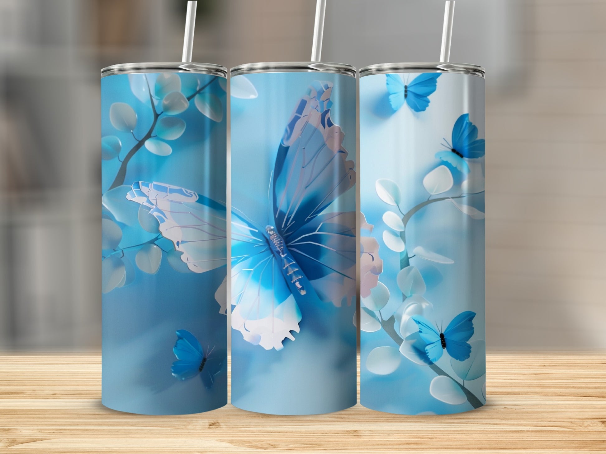 Three blue tumblers with butterfly and branch designs.