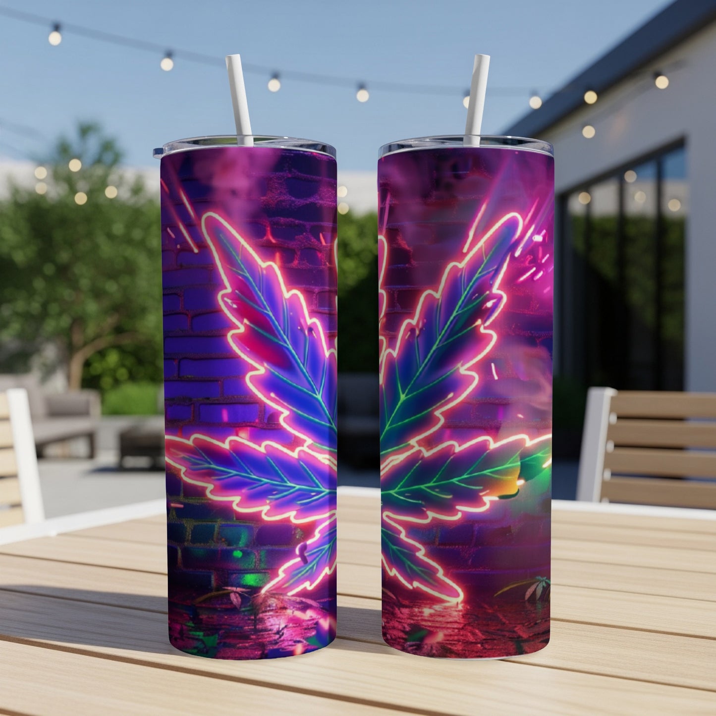 Two neon cannabis leaf tumblers with straws on a wooden table.