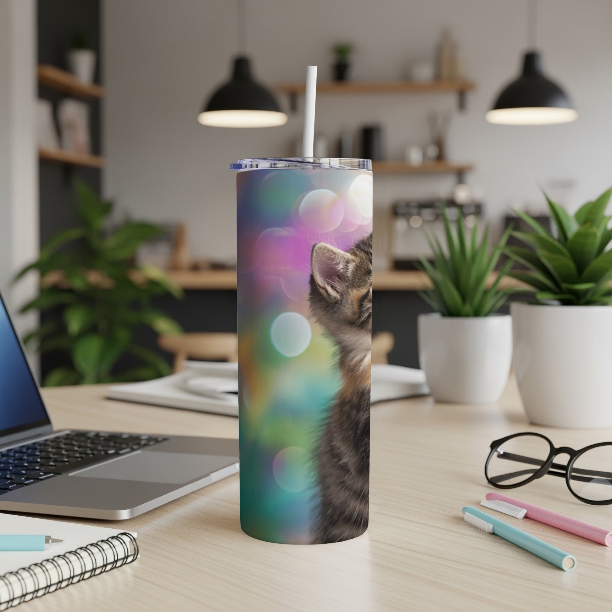 Kitten with bokeh background on a white tumbler with a straw.