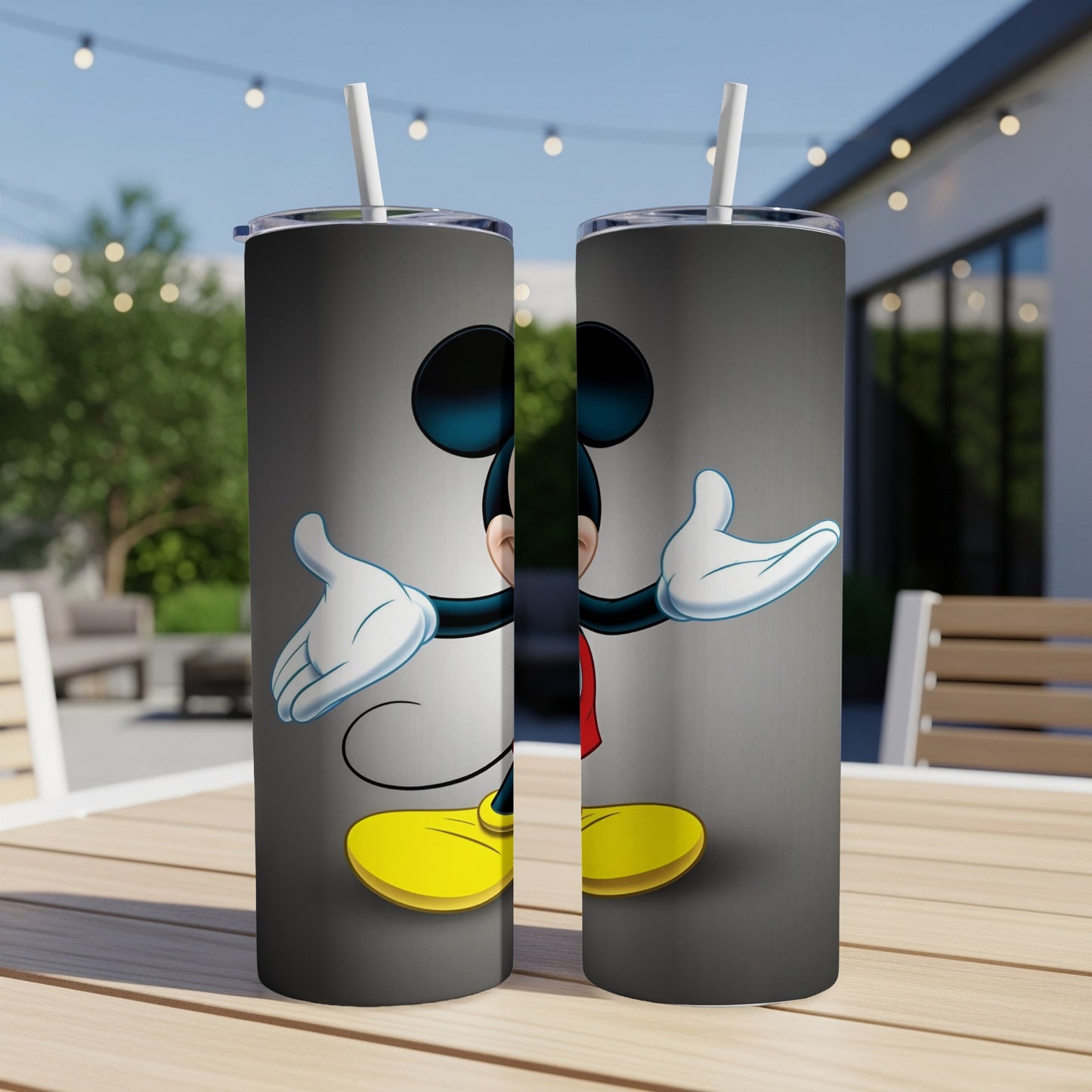 Two tumblers featuring Mickey Mouse on a table with a blurred outdoor background.