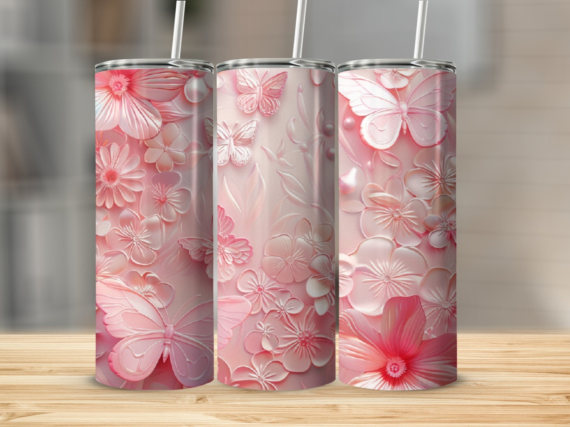Pink floral and butterfly patterned tumblers on a wooden surface.