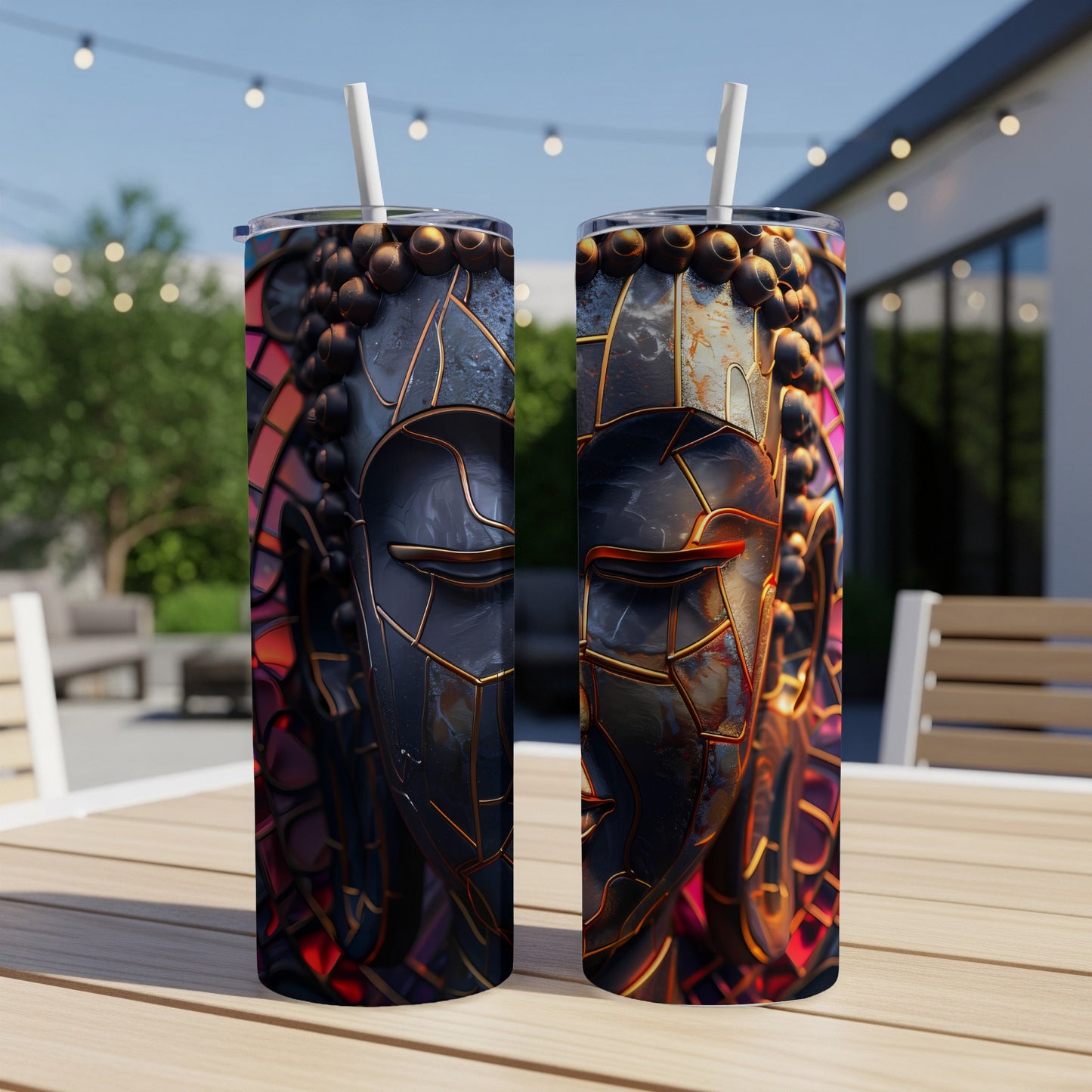 Two tumblers with a mosaic Buddha face design sit on a wooden table.