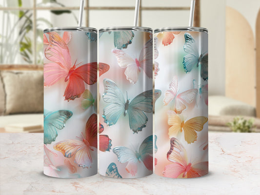 Three tumblers with watercolor butterfly designs in a pink and blue ombre style.