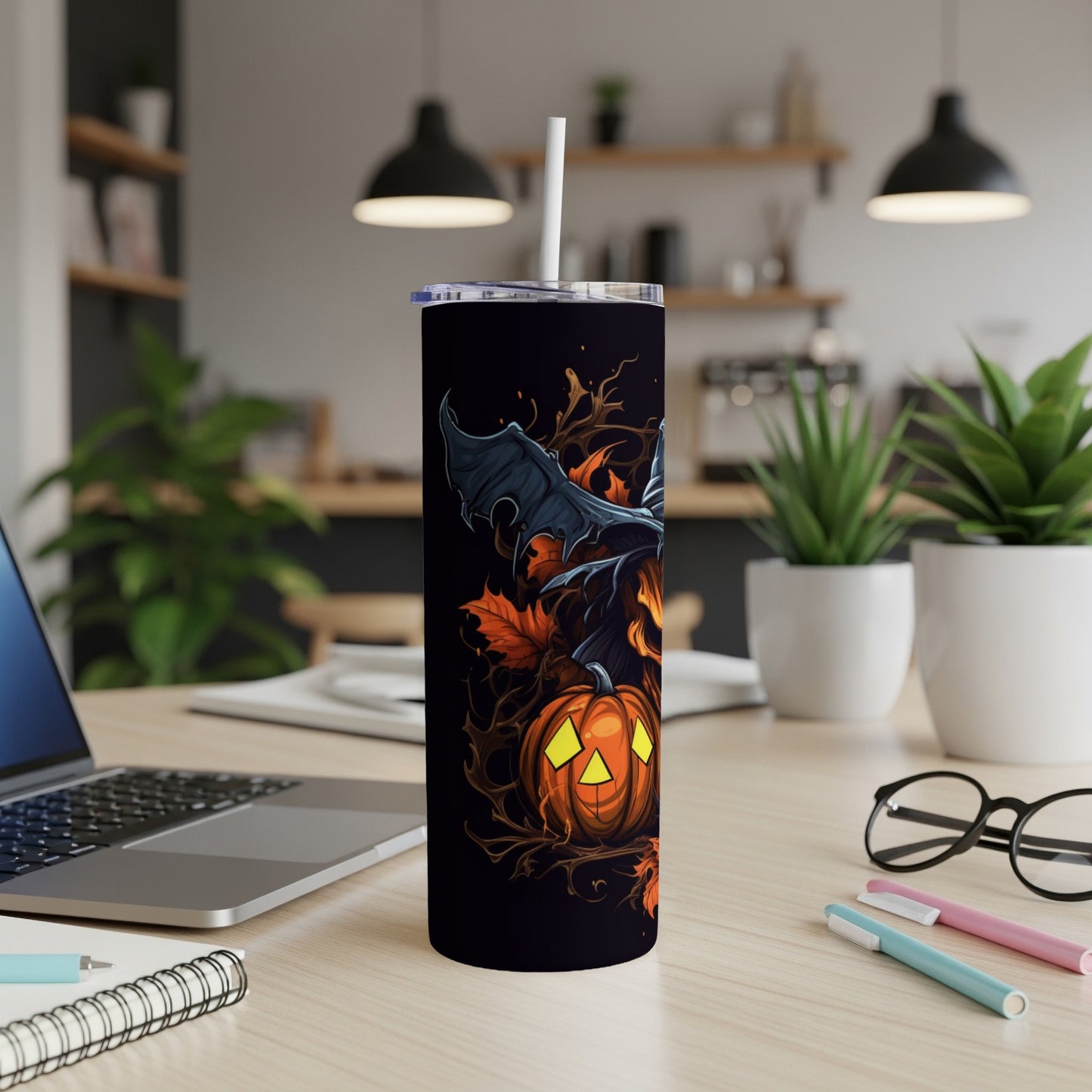 Black tumbler with Halloween design of a pumpkin, witch hat, and bat wings.