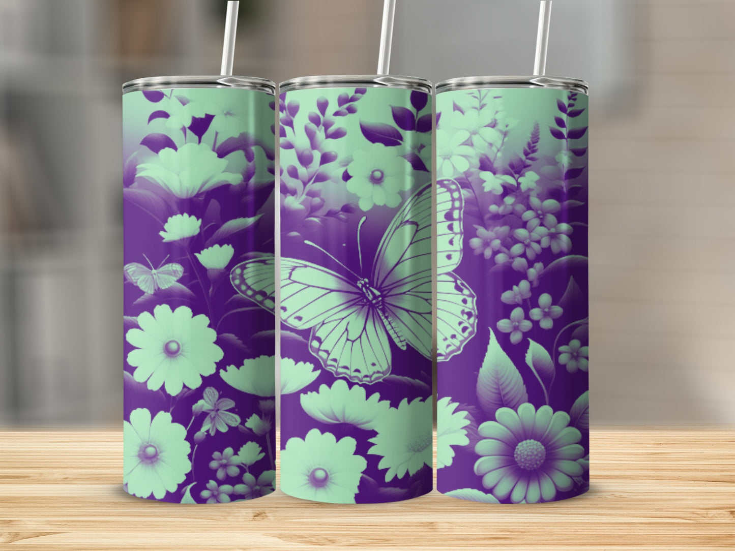 Purple and mint green butterfly and floral patterned tumblers on a wooden surface.