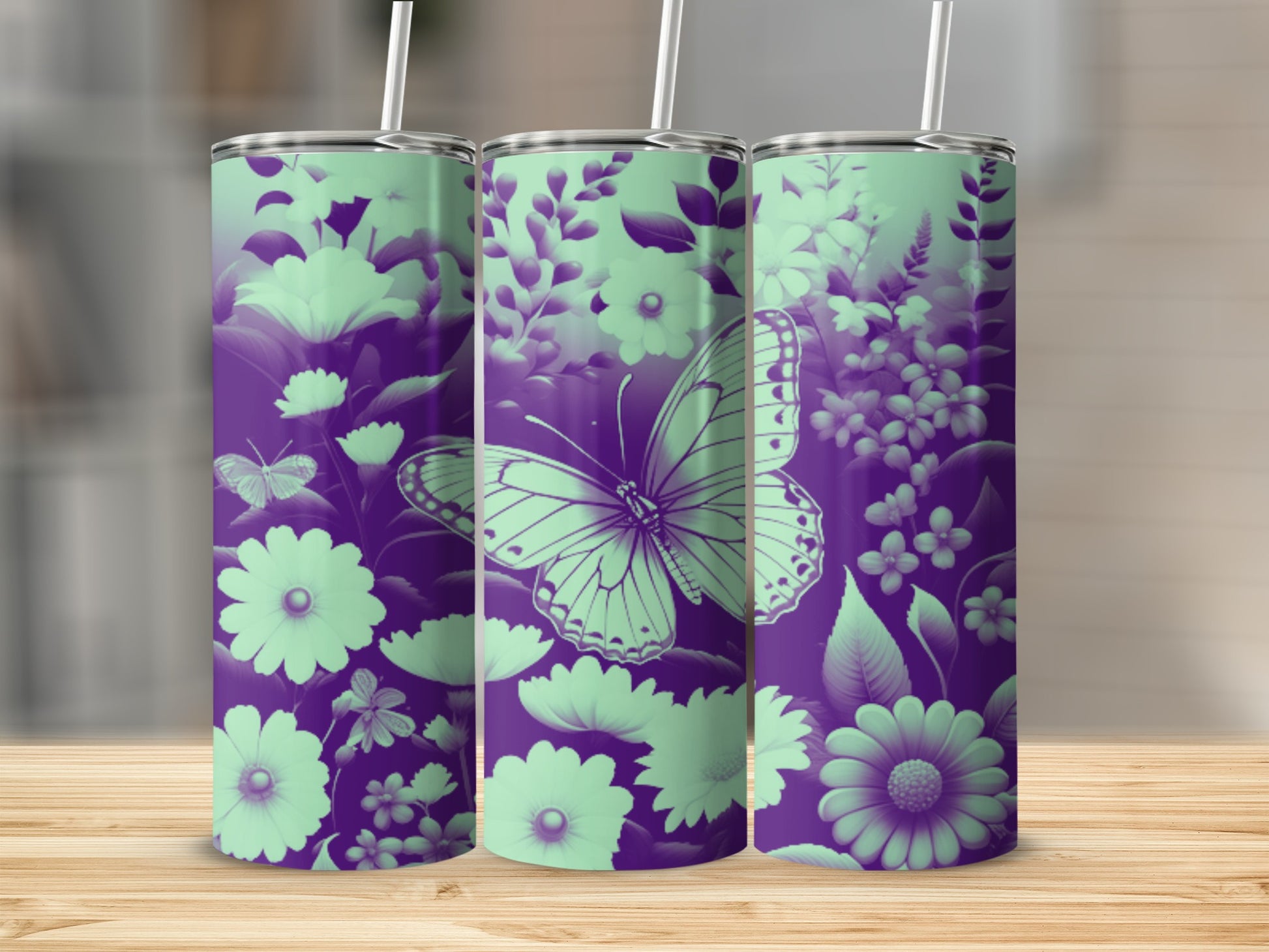 Purple and mint green butterfly and floral patterned tumblers on a wooden surface.