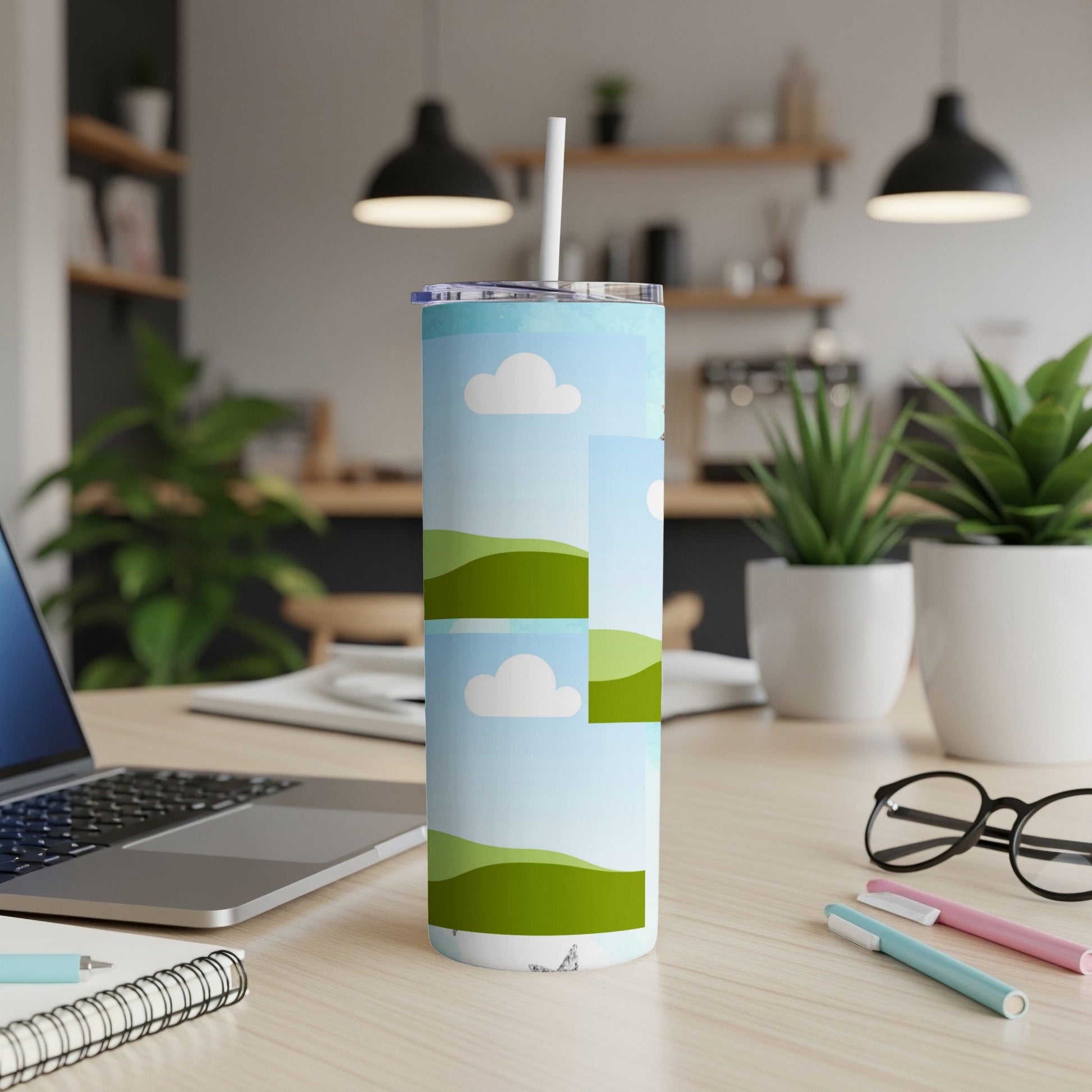 Tall tumbler with a green landscape and cloud pattern, featuring a straw.