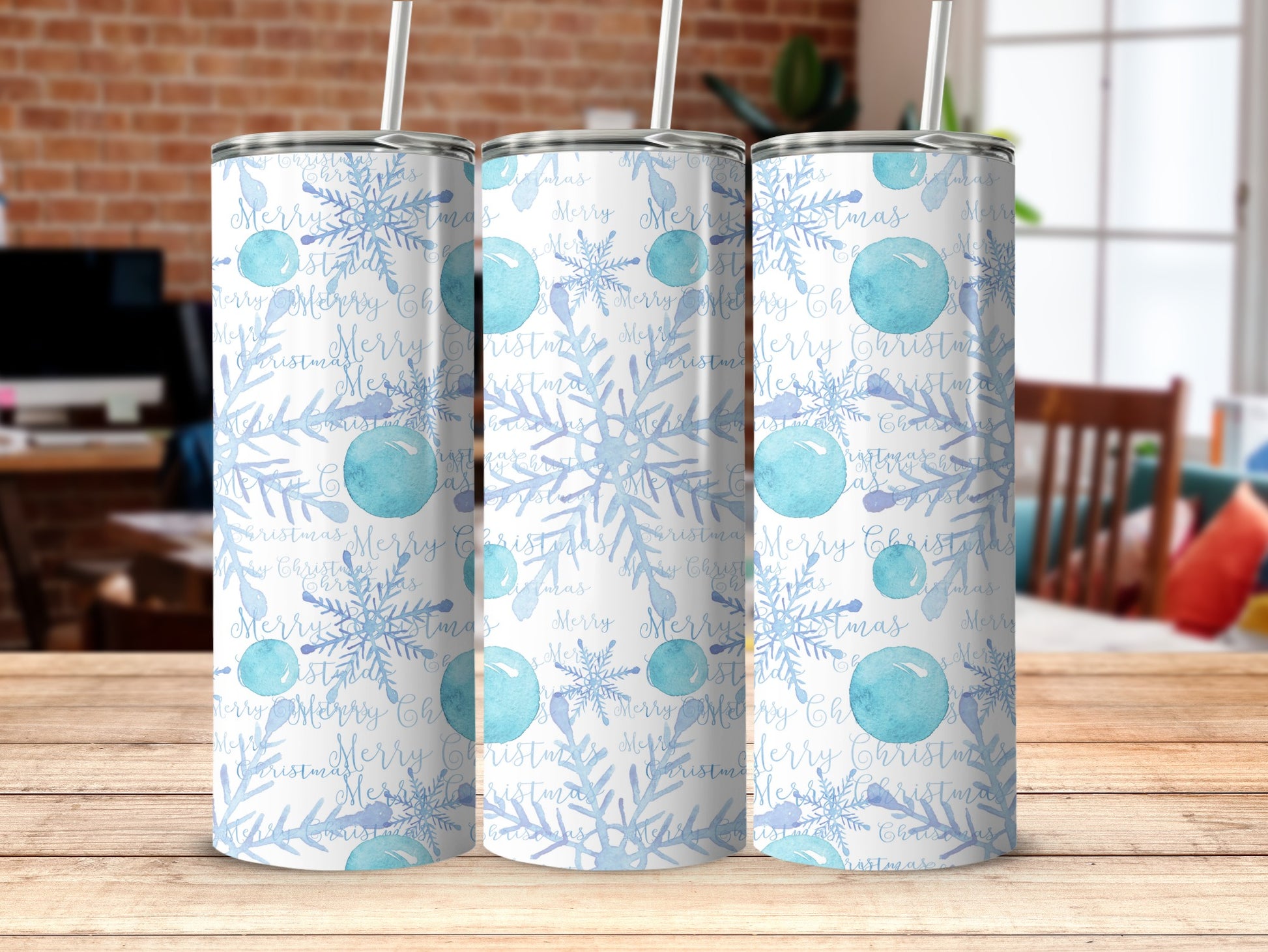 Tumblers with blue snowflakes and "Merry Christmas" text on a wooden surface.