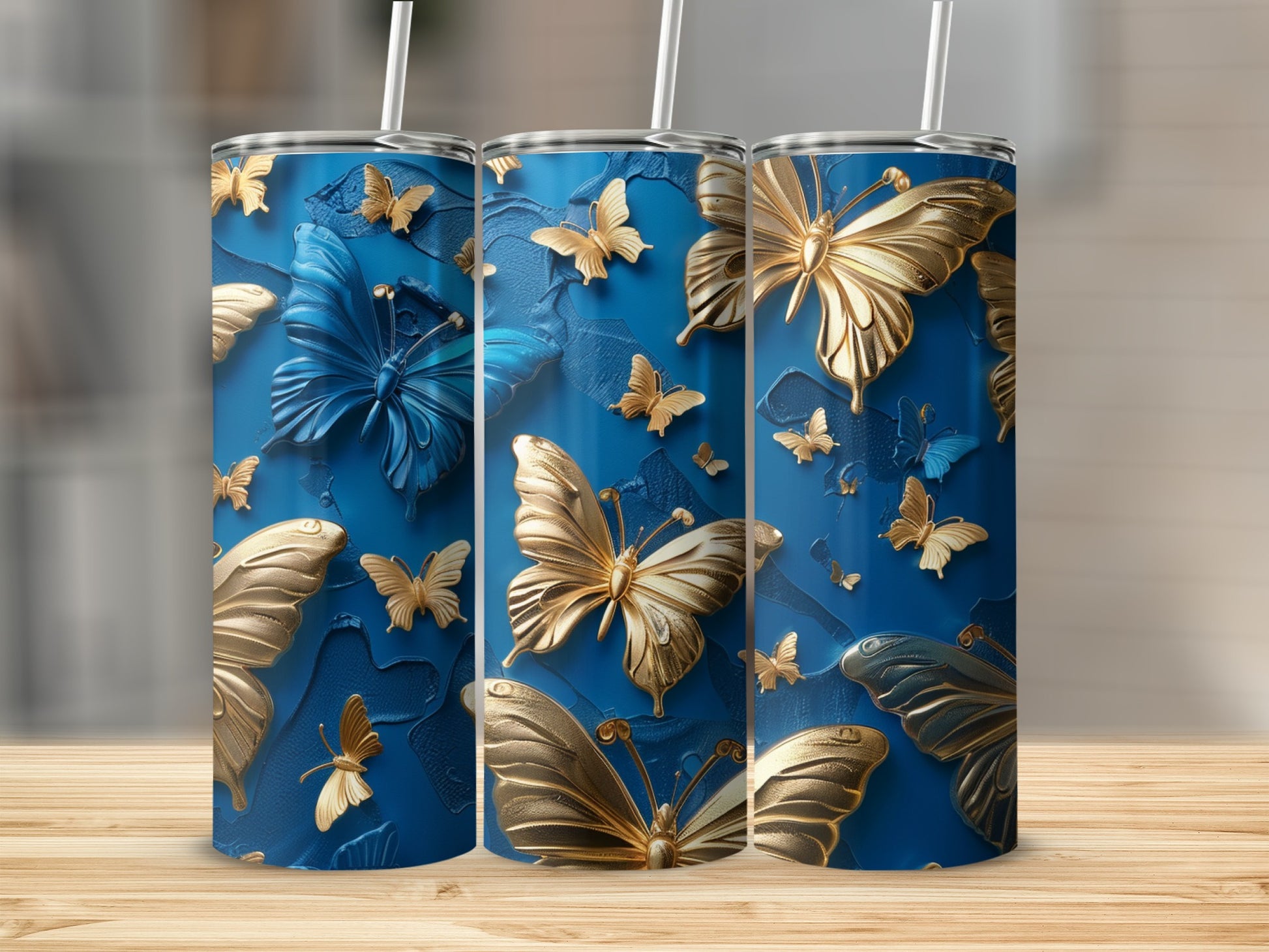Three blue tumblers with embossed gold and blue butterflies.