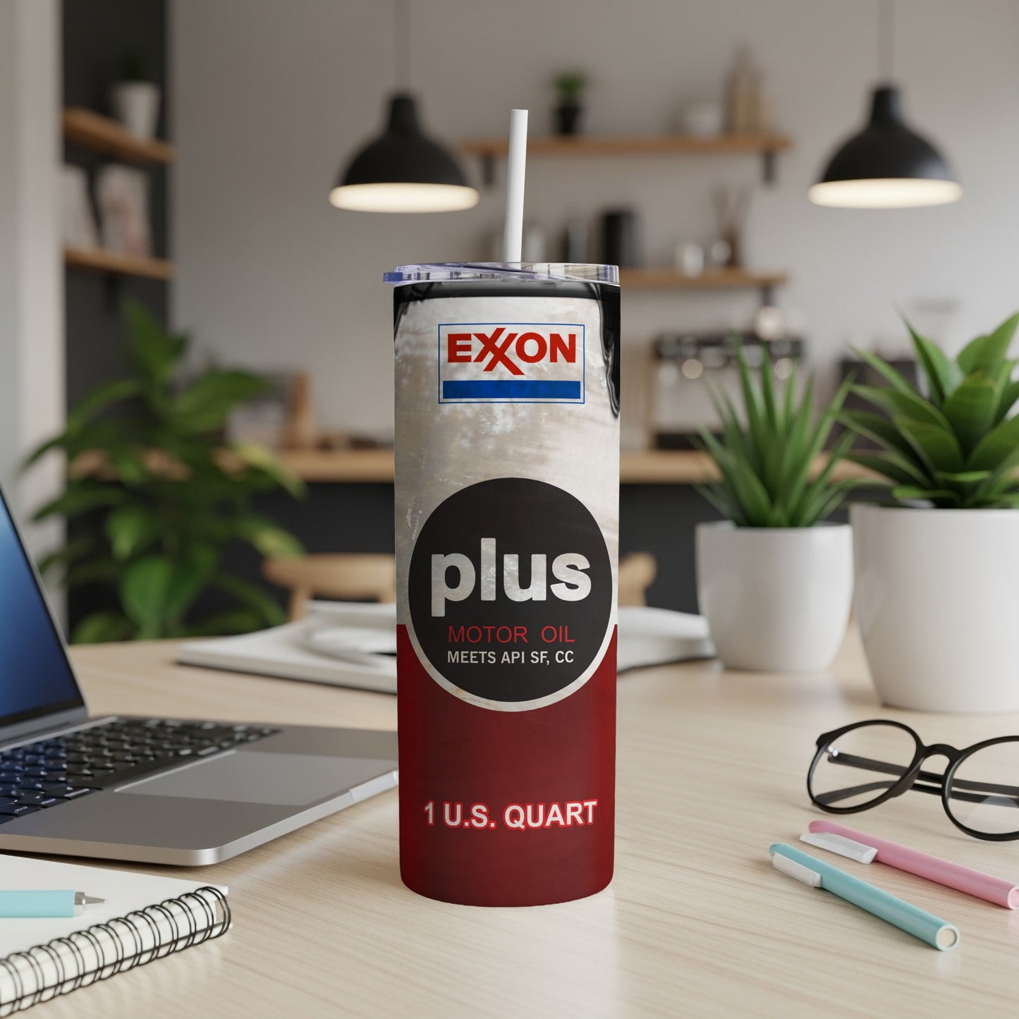 Exxon Motor Oil Plus tumbler with text and straw on a desk.