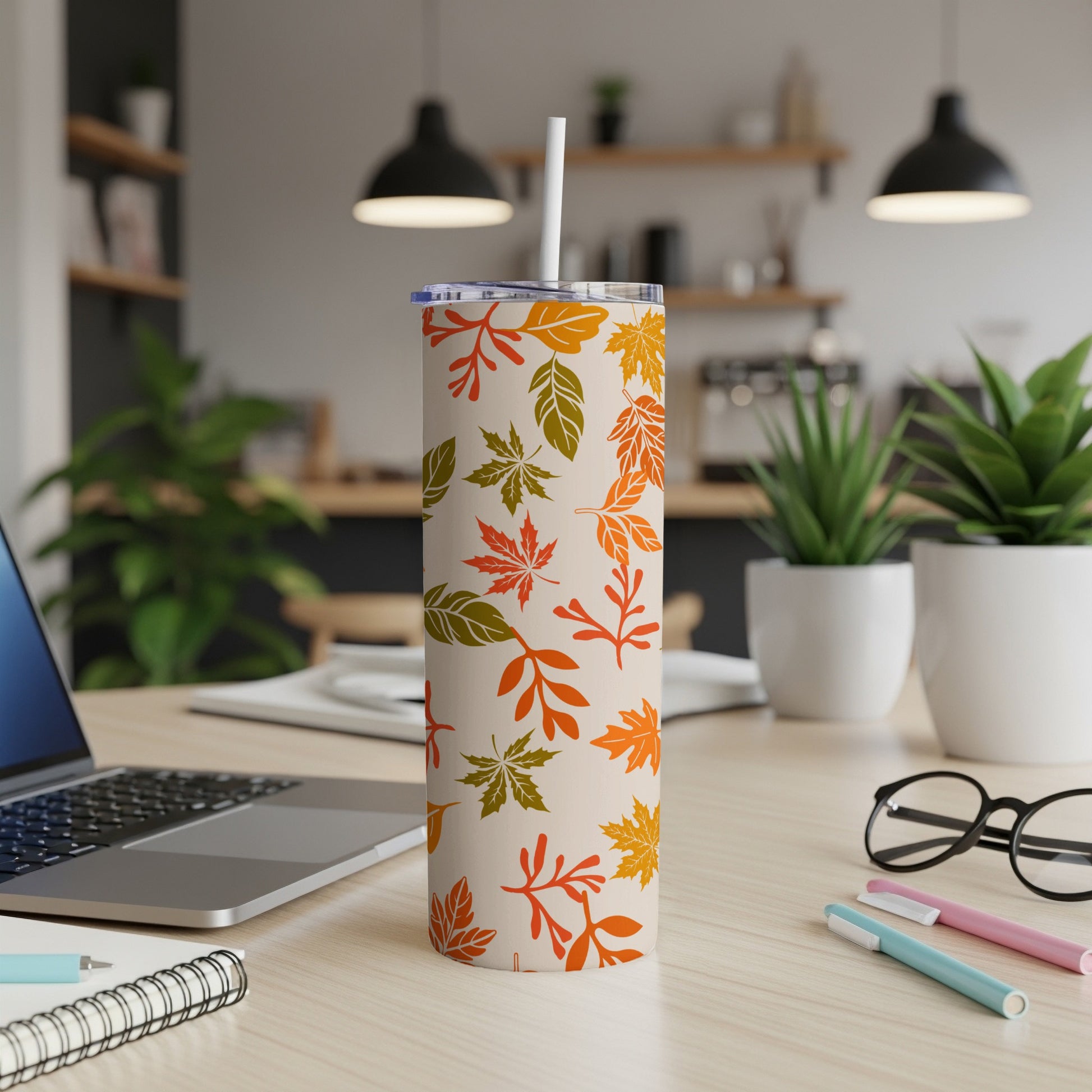 Beige tumbler with a repeating pattern of colorful autumn leaves.