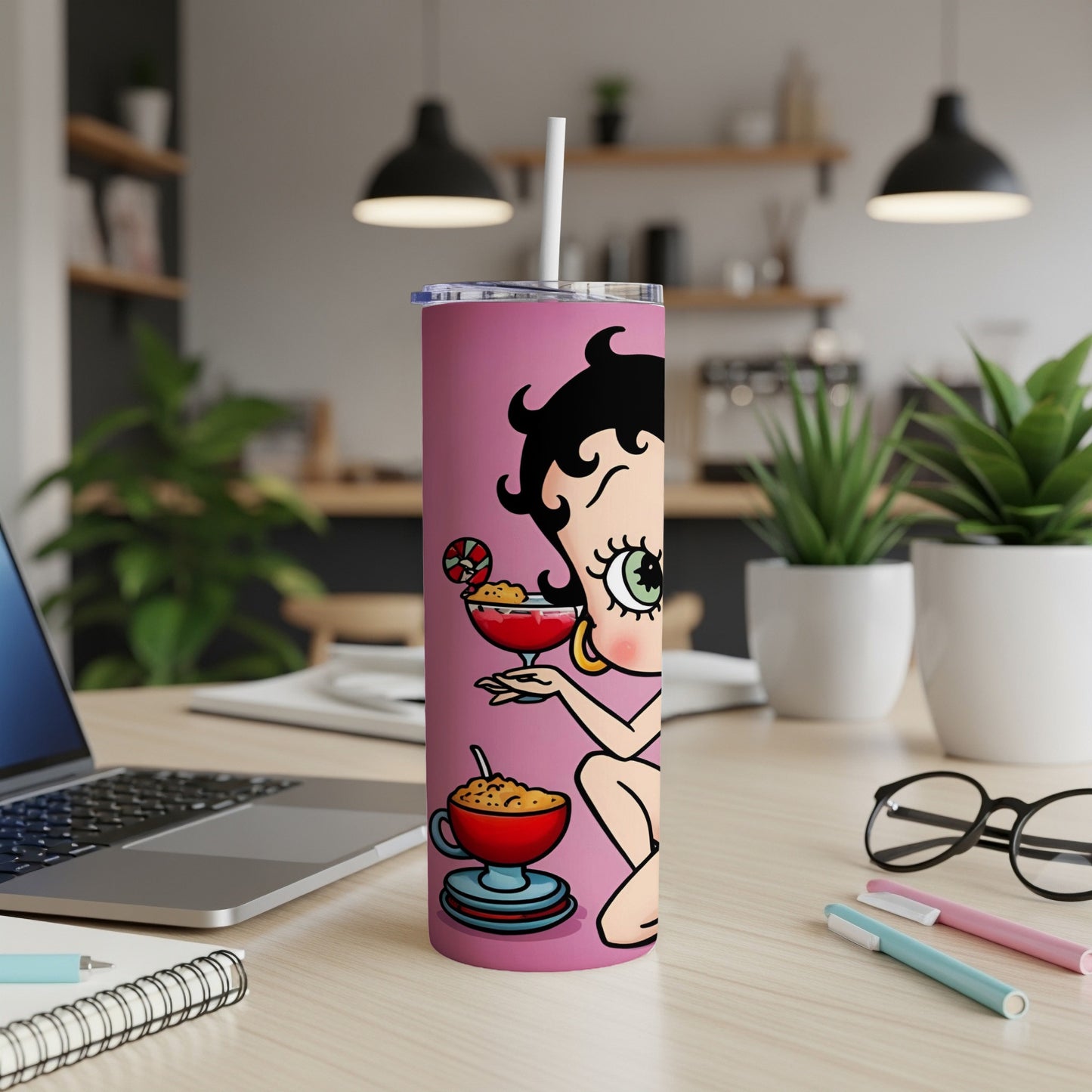 Betty Boop with martini and cocktail on pink tumbler, on desk.