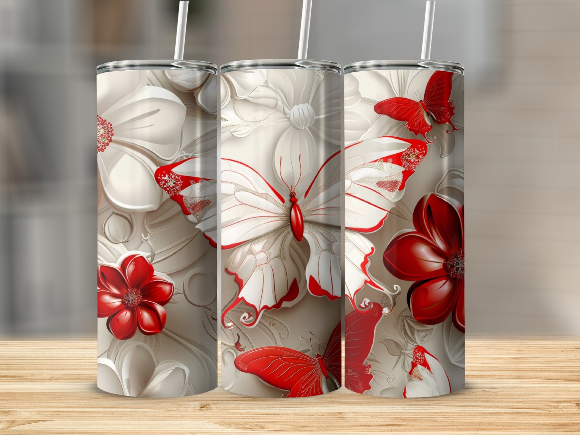 Three tumblers with white and red floral and butterfly designs.