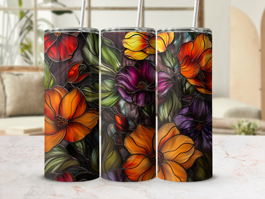 Three floral tumblers with stained glass effect and straw, on a marble countertop.