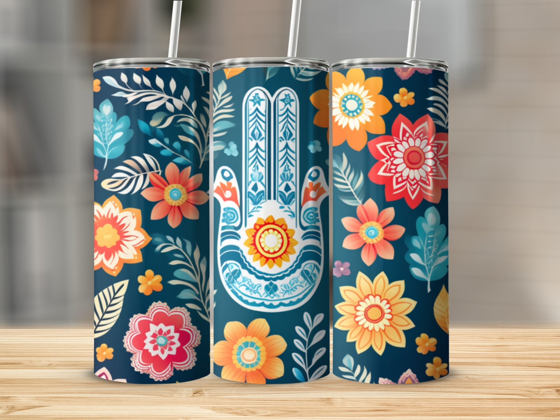 Three tumblers with a floral and Hamsa hand design on a wooden surface.
