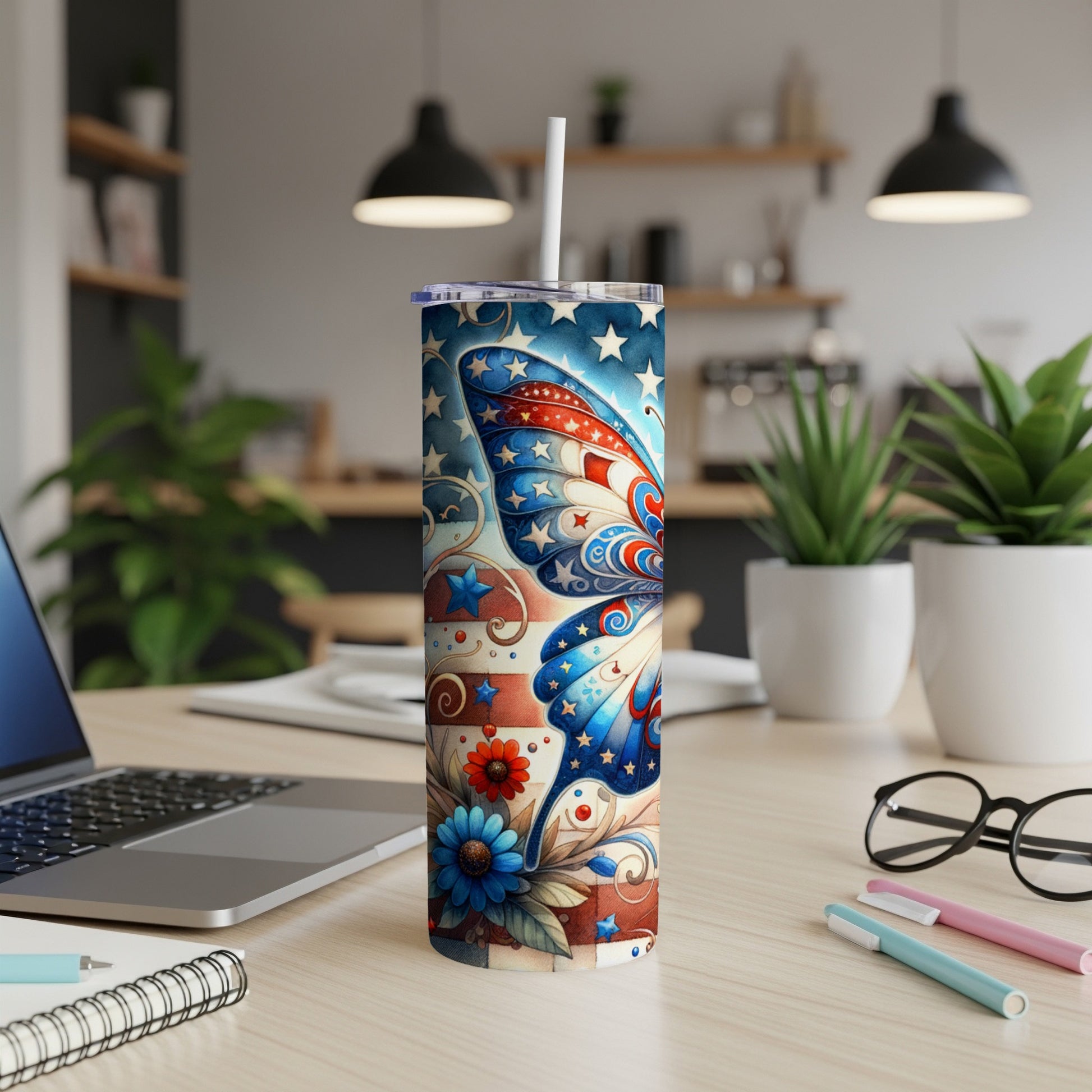 USA flag butterfly design tumbler with straw on desk.