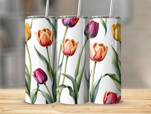 Three tumblers with floral tulip designs stand on a wooden surface.