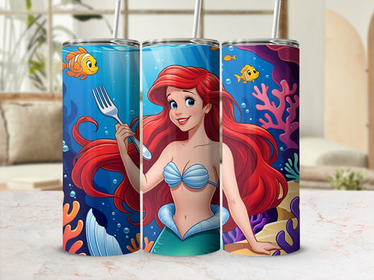 Ariel the mermaid holds a fork in an underwater scene with coral and fish.