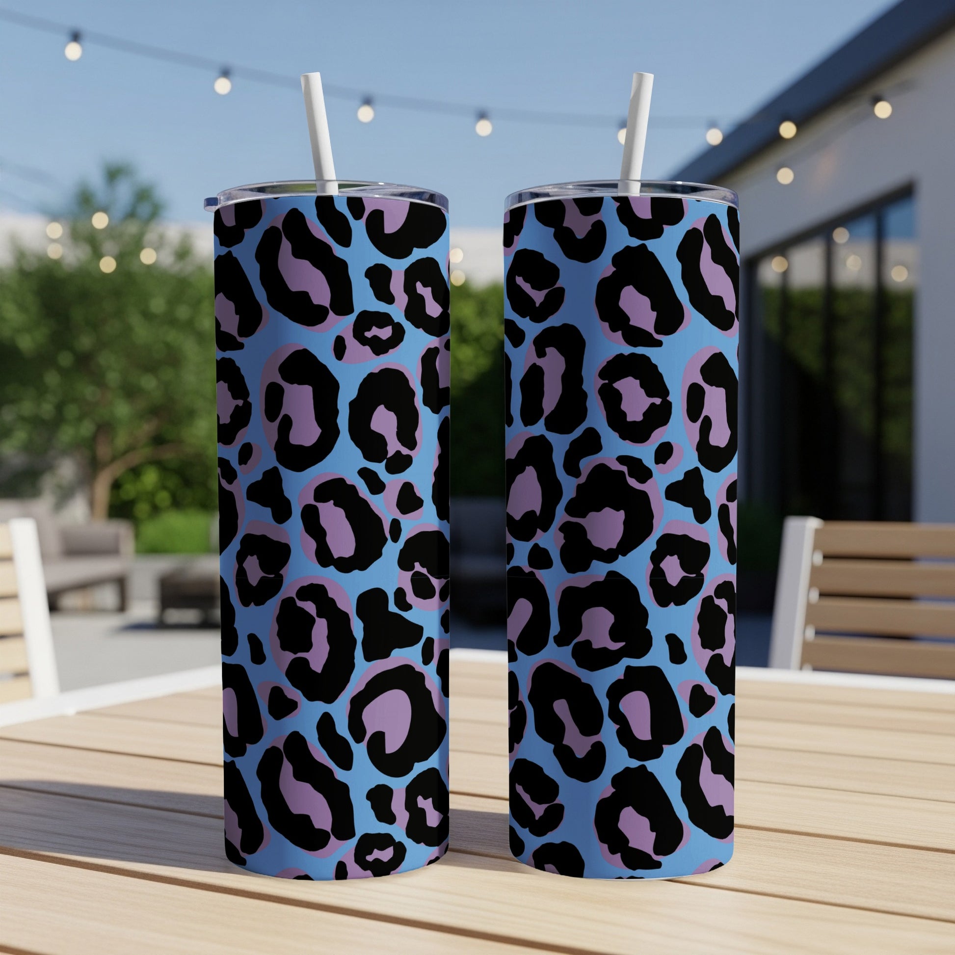 Two skinny tumblers with light blue background and black and purple leopard print.