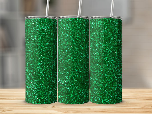 Three green glitter tumblers with white straws on a wooden surface.