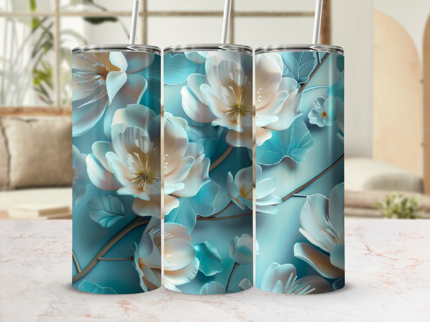 Three teal tumblers with a floral pattern of white and yellow flowers.