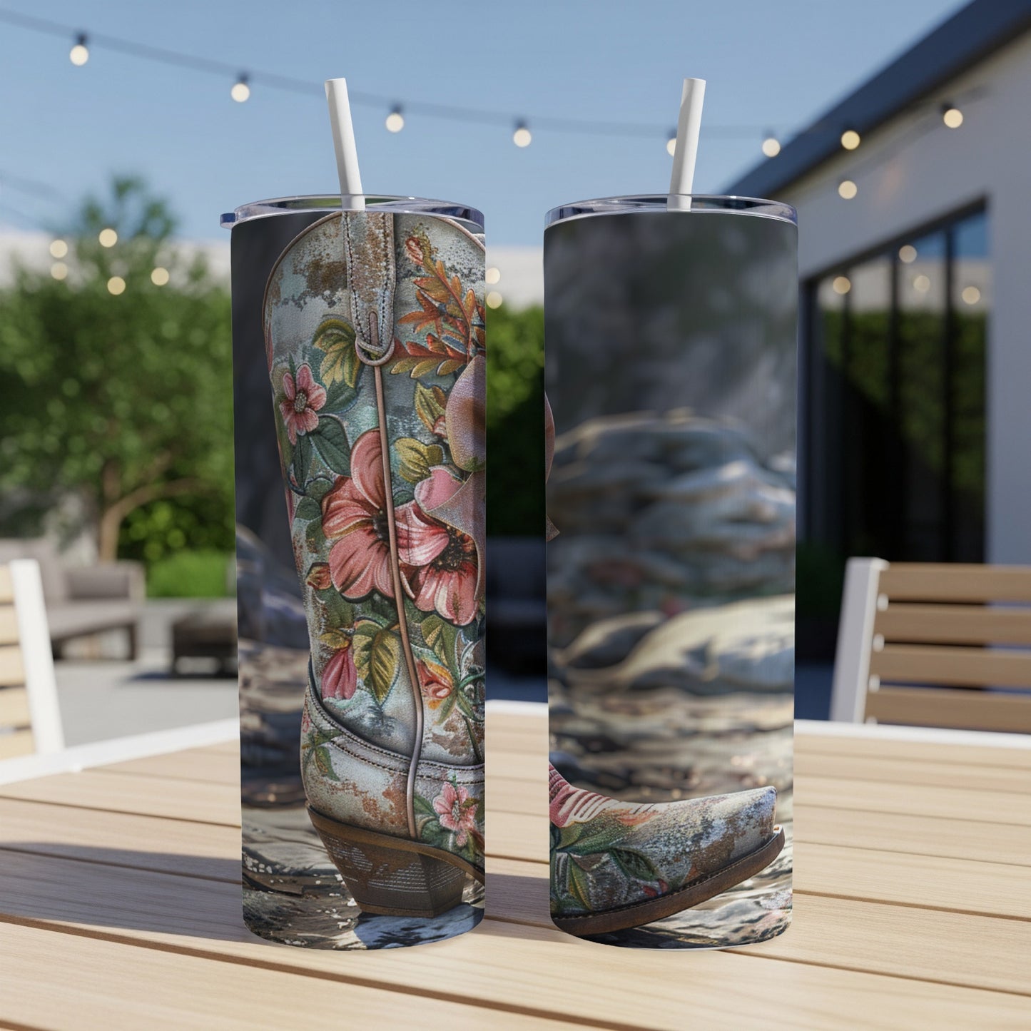 Floral cowboy boots on a tumbler, displayed outdoors on a table.