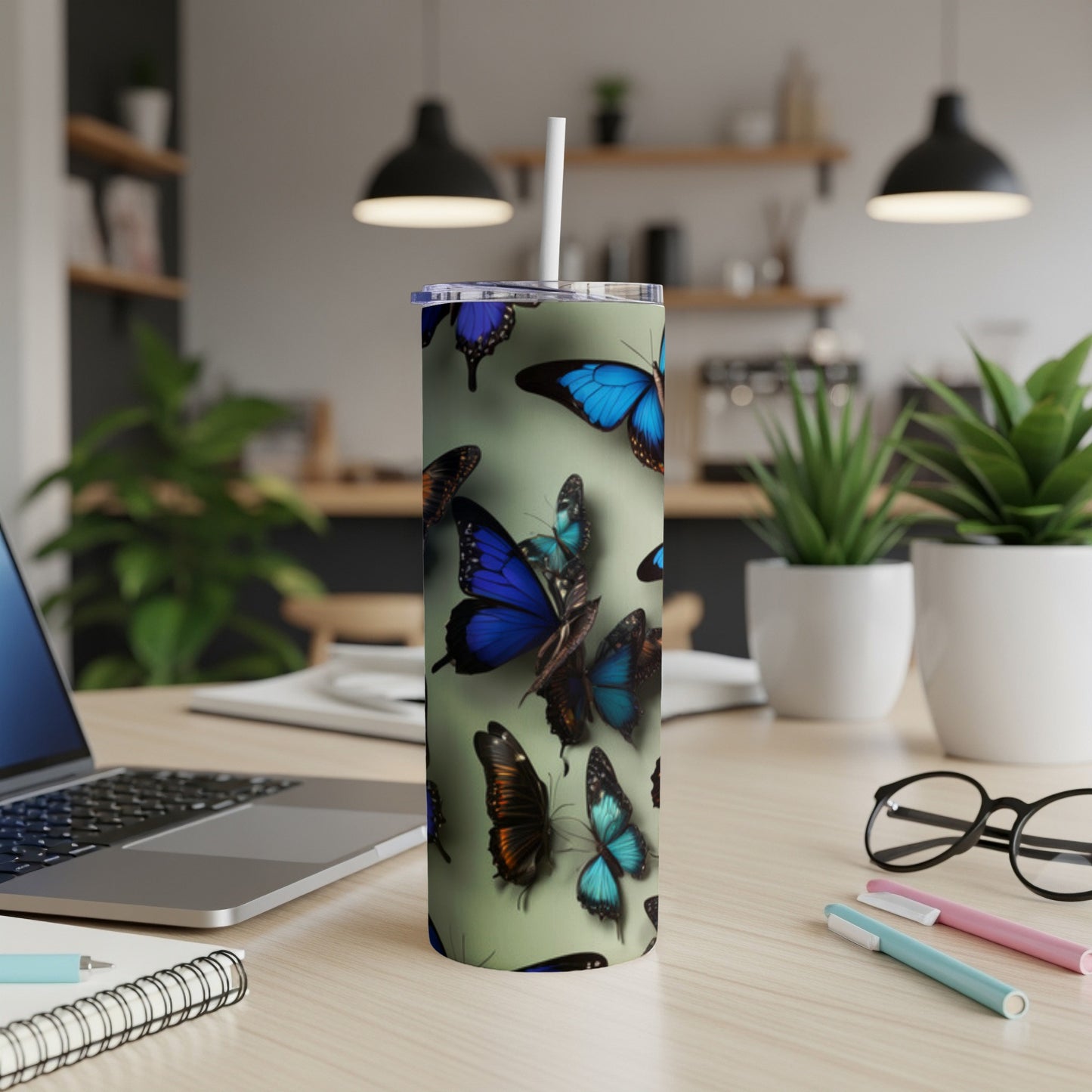 Blue and green butterflies on a light green tumbler with a straw.