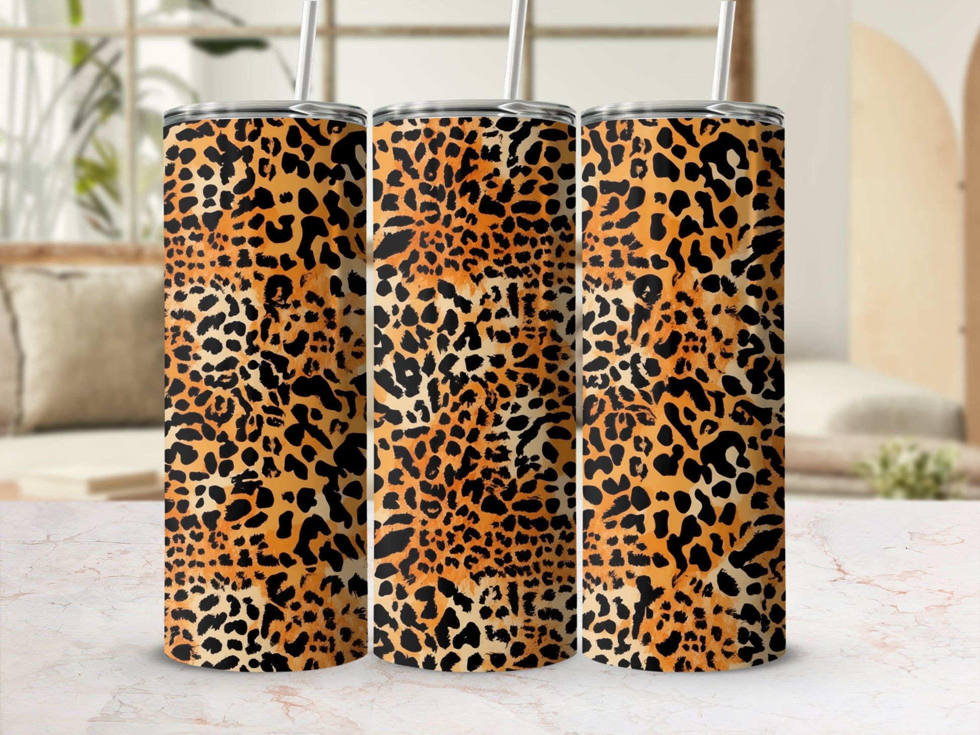 Three tumblers with a leopard print pattern stand on a marble surface.