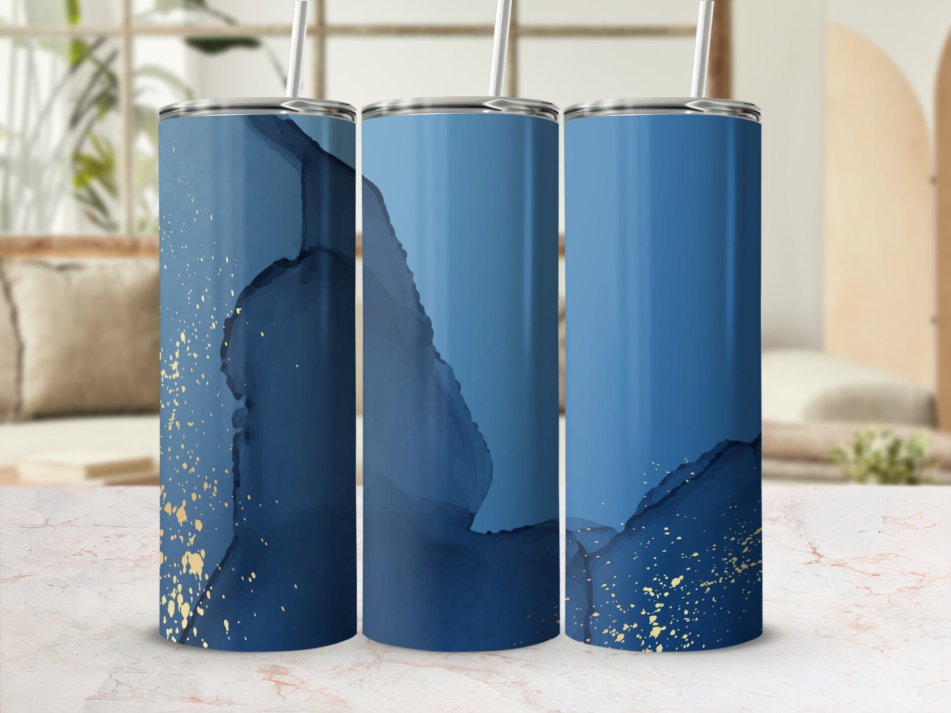 Three blue tumblers with gold speckles on a marble surface.