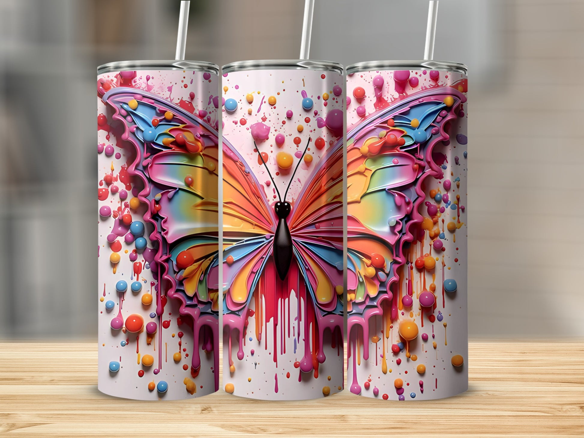 Rainbow butterfly design on three white tumblers with colorful drips.