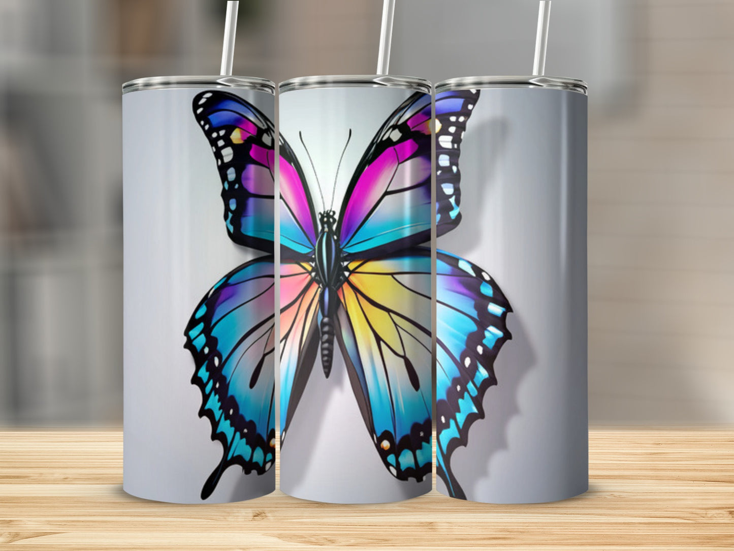 Three tumblers featuring a vibrant, colorful butterfly design.