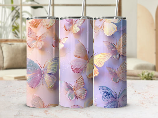 Three tumblers with iridescent butterfly designs on a textured surface.