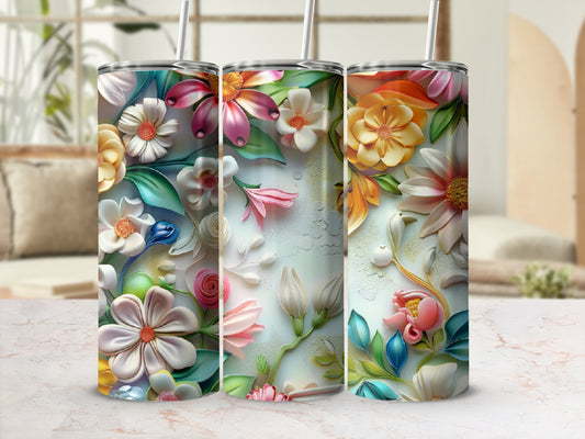 Three tall tumblers with vibrant floral designs and straw lids.