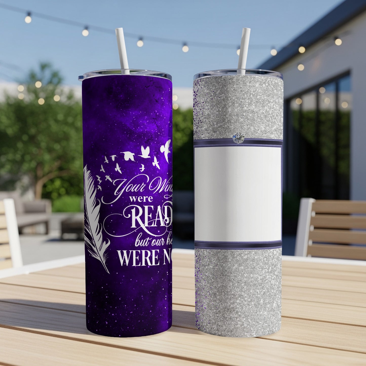 Purple tumbler with feathers and text, next to a silver tumbler.