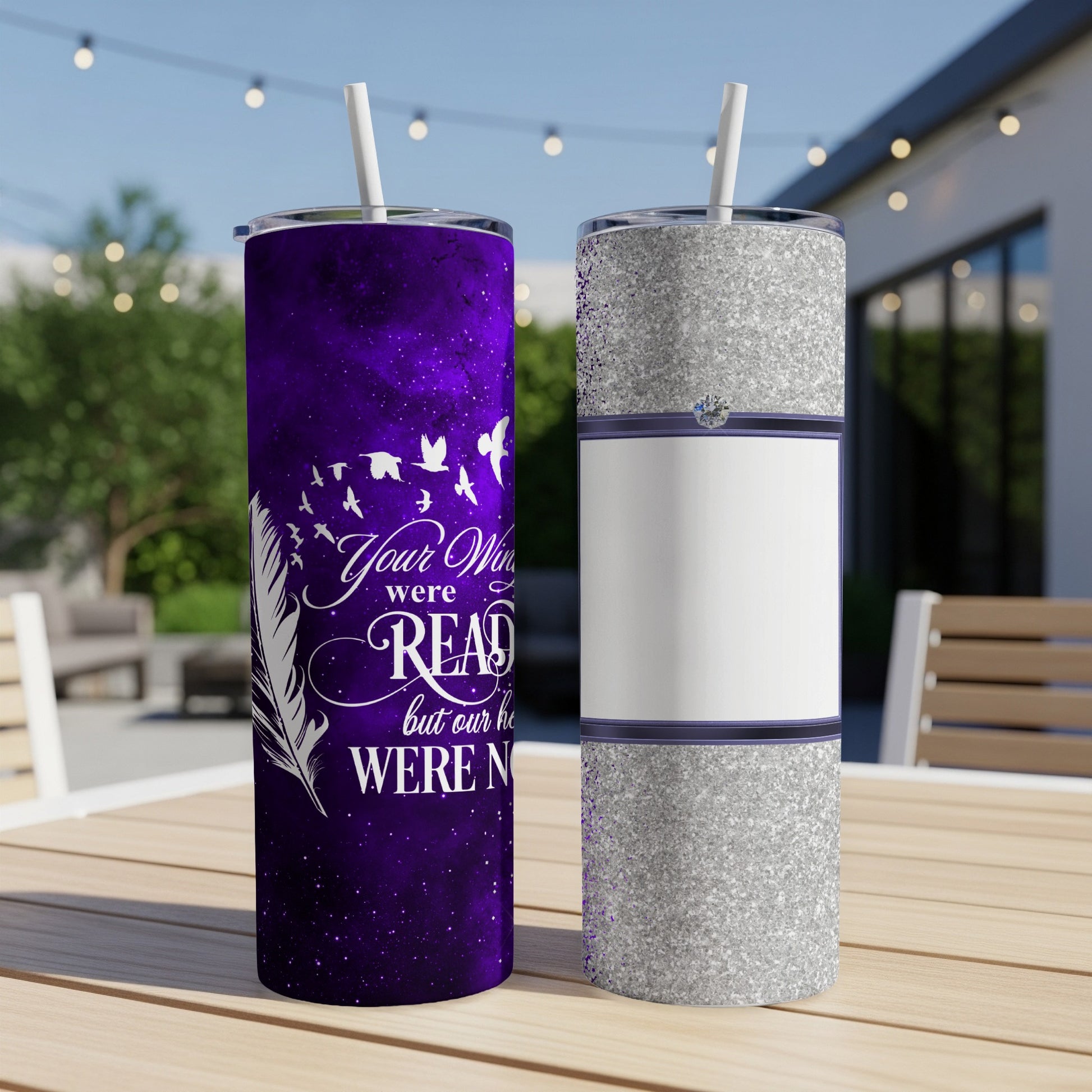 Purple tumbler with feathers and text, next to a silver tumbler.