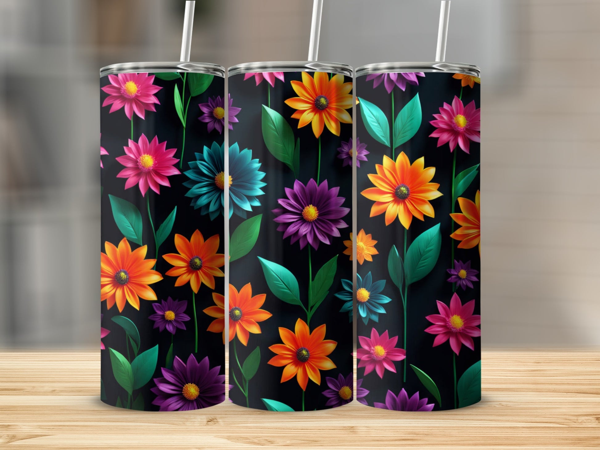 Three tumblers with vibrant floral patterns on a wooden surface.