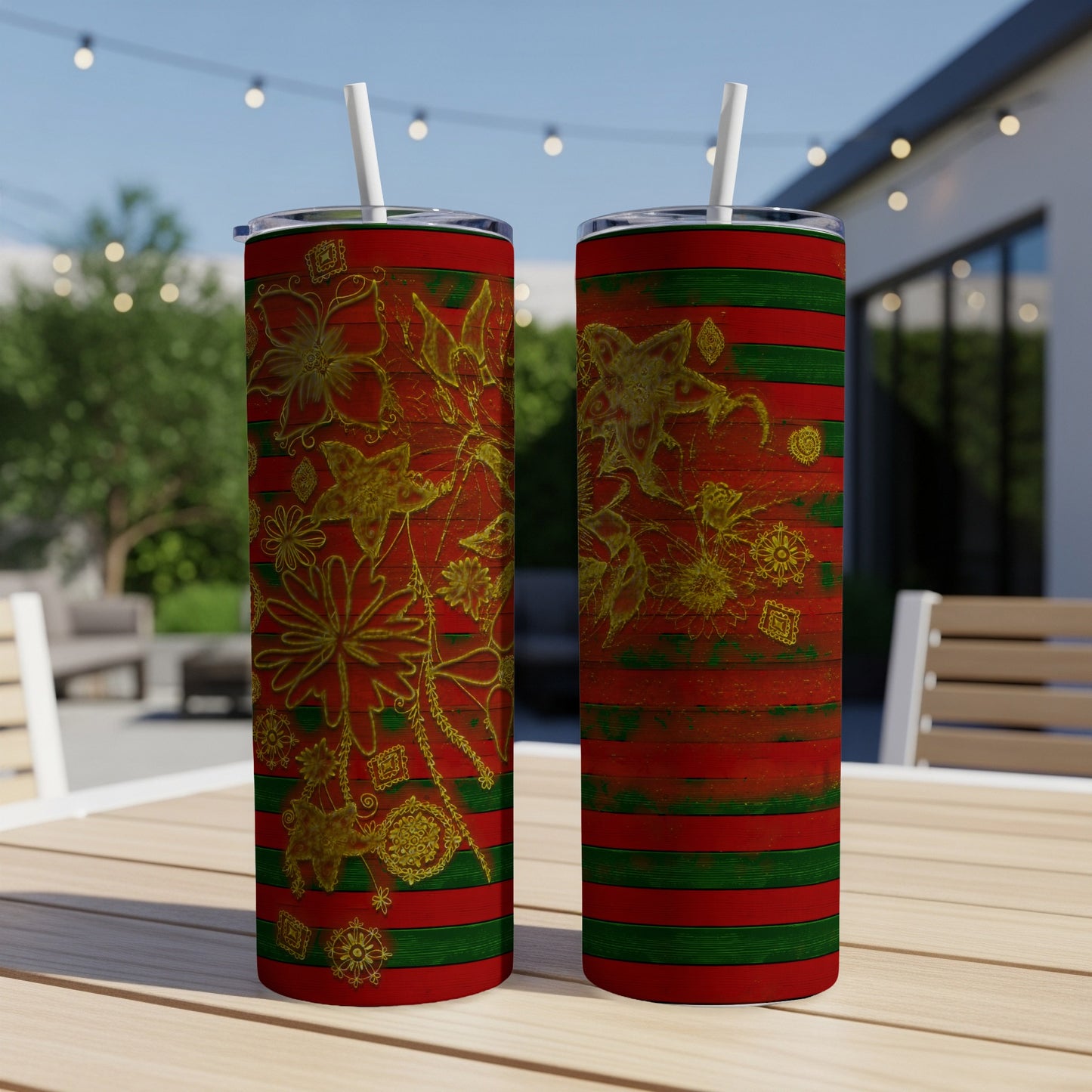 Two tumblers with red, green, and gold floral designs on a table.