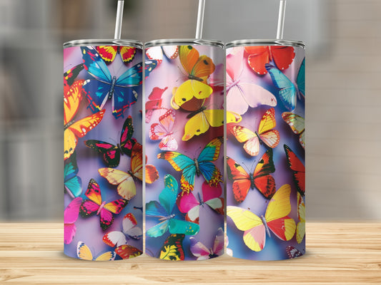 Three tumblers featuring colorful butterfly patterns on a wooden surface.