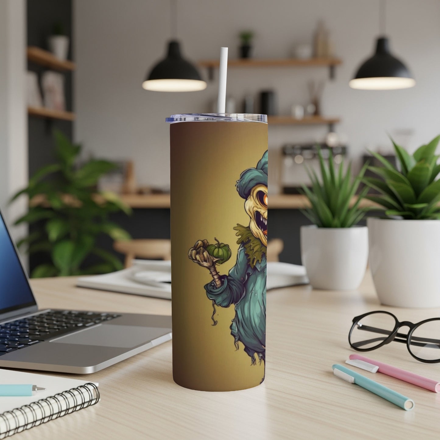 Tumbler with a cartoon scarecrow holding a pumpkin on a brown background.