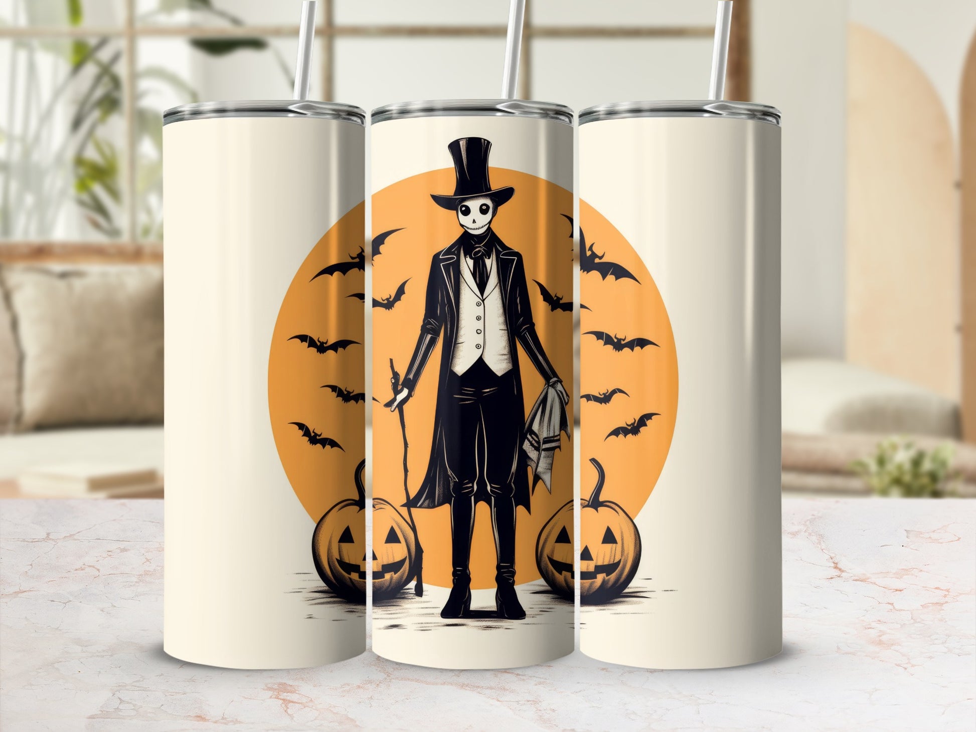 Three tumblers featuring a skeleton in a top hat and suit with bats and pumpkins.