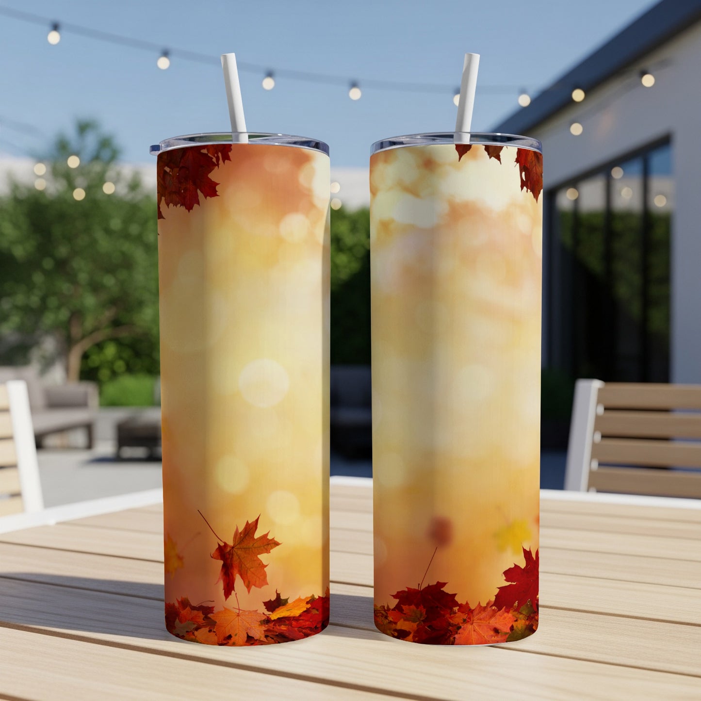 Two tumblers with autumn leaves and bokeh background.