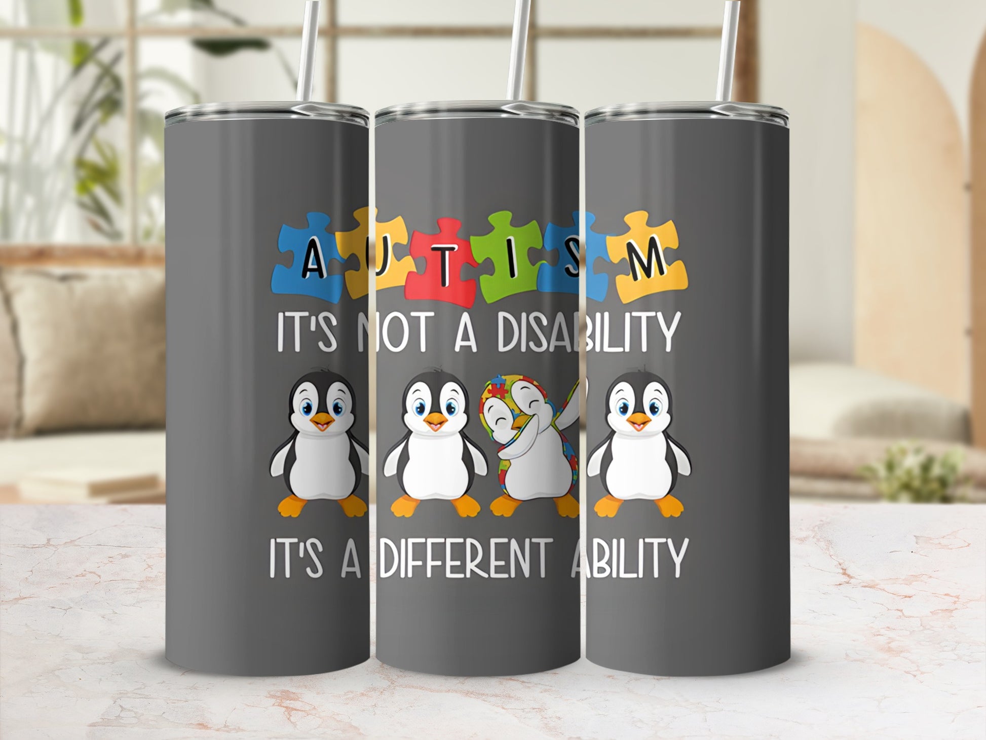 Tumbler with penguins, puzzle pieces, and "Autism It's Not A Disability It's A Different Ability" text.