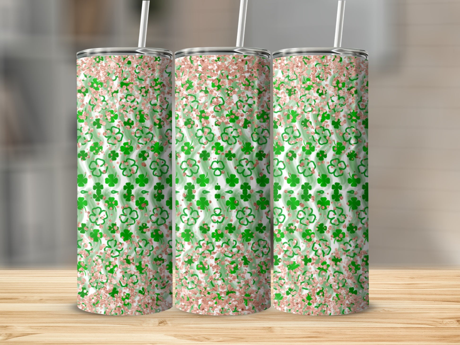 Three tall tumblers with a green clover and rose gold glitter pattern.